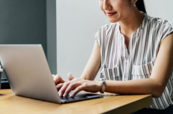 A woman typing on a laptop.