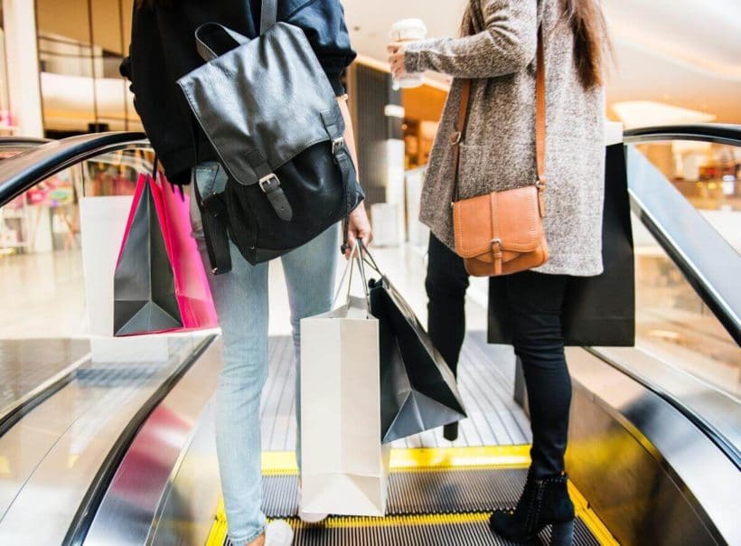 Women with shopping bags on an escalator